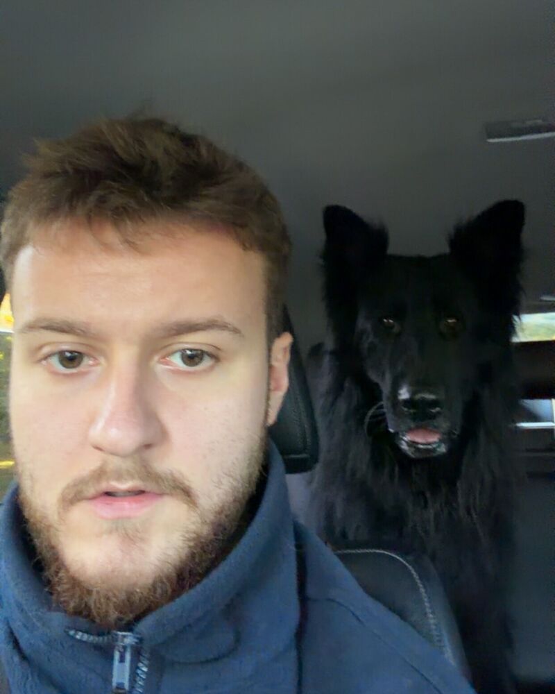 Zachary z czarnym psem w samochodzie